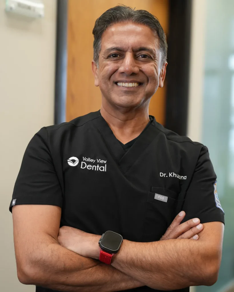 Man in dental scrubs, arms crossed.